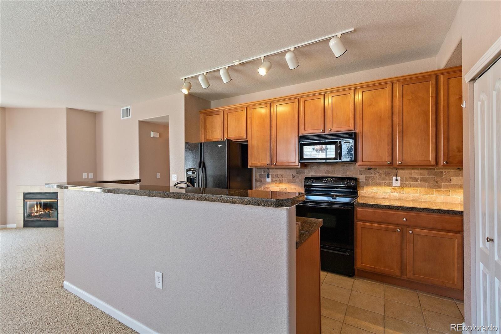 5534 Lewis Street, Unit 206 Arvada, CO 80002 - Photo 9 of 27 a kitchen with stainless steel appliances a stove refrigerator sink and cabinets