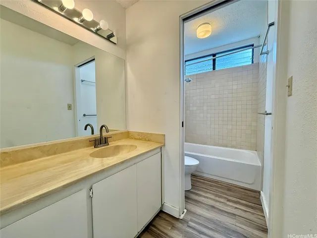 a bathroom with a granite countertop sink toilet and shower