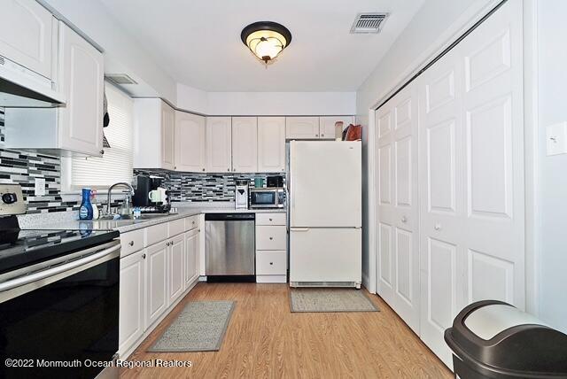 329 Briggs Avenue Forked River, NJ 08731 - Photo 6 of 15 a kitchen with a refrigerator a stove a sink dishwasher and a stove with wooden floor