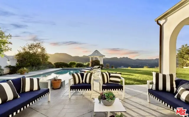 a view of a patio with couches chairs and wooden floor