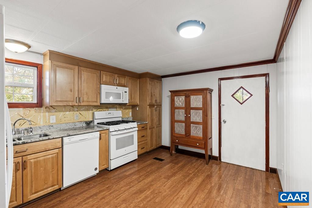 1066 Stevens Cove Road Lovingston, VA 22949 - Photo 6 of 34 a kitchen with a sink wooden floor and a stove