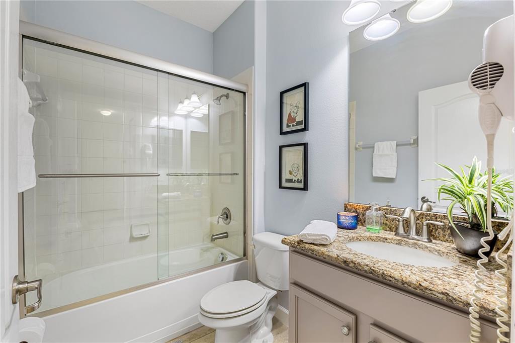 9006 Majesty Palm Road Kissimmee, FL 34747 - Photo 10 of 56 a bathroom with a granite countertop sink a toilet and shower