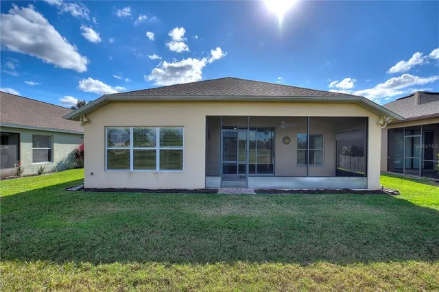 a living room with furniture kitchen view and a wooden floor