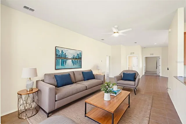 an empty room with wooden floor chandelier fan and windows