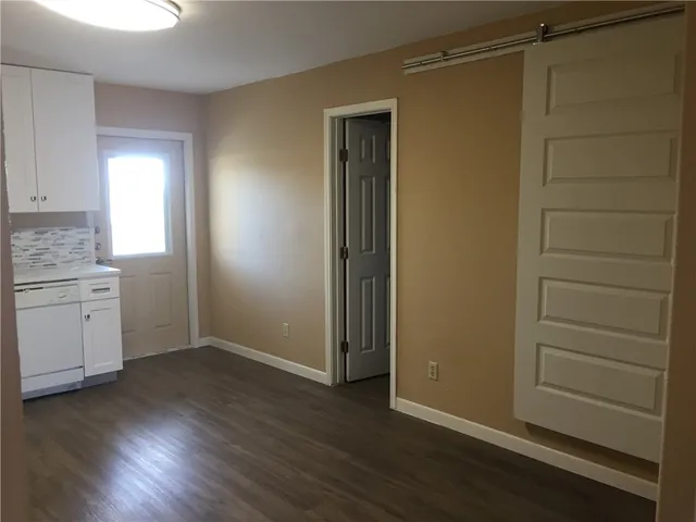 an empty room with wooden floor and cabinet