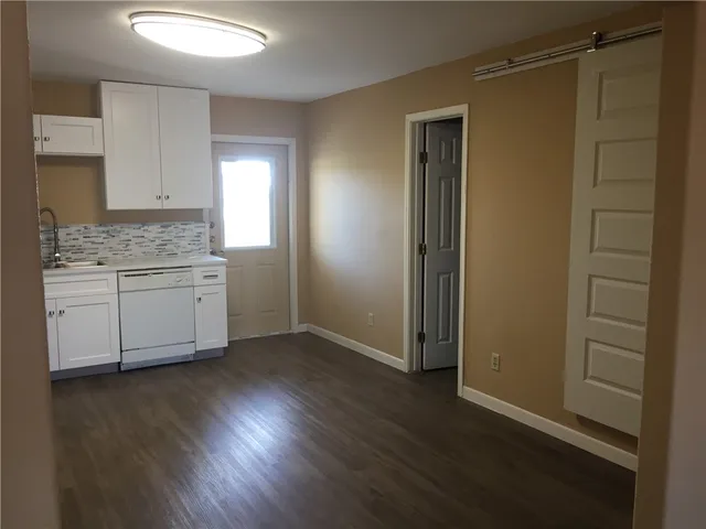 an empty room with wooden floor and a window