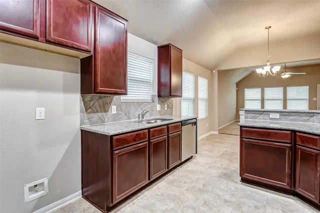 a kitchen with stainless steel appliances granite countertop a sink and a stove