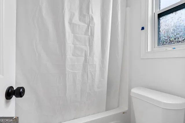 a bathroom with a shower curtain and a toilet