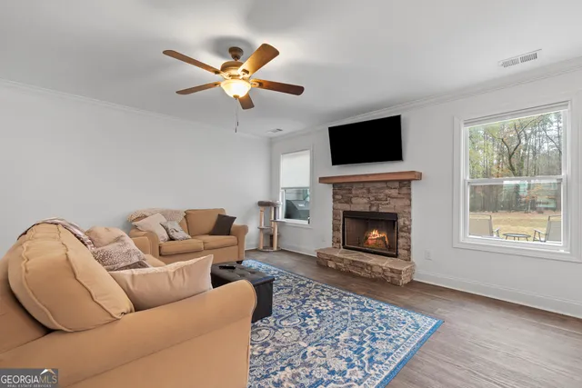 a living room with furniture a flat screen tv and a fireplace
