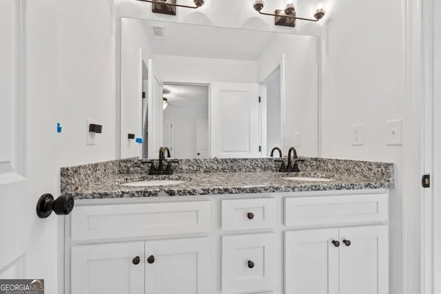 a bathroom with a granite countertop sink and a mirror