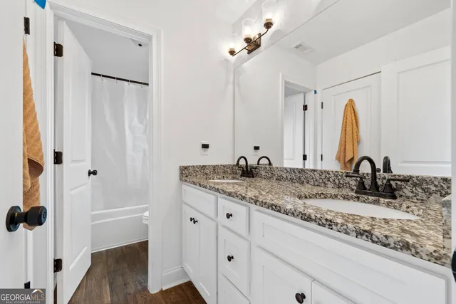 a bathroom with a granite countertop sink and a mirror