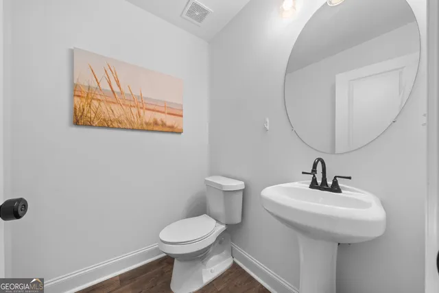 a bathroom with a toilet a sink and mirror