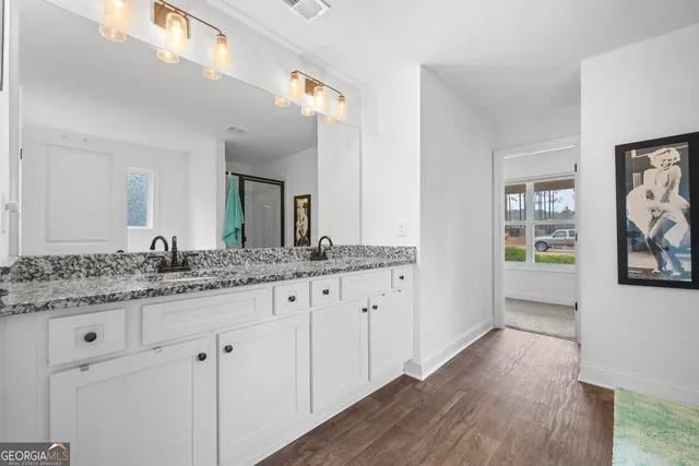 a bathroom with granite countertop a sink and a mirror