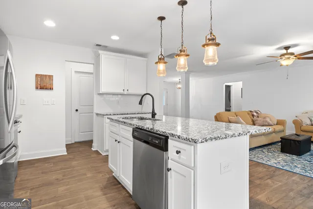 a kitchen with stainless steel appliances granite countertop a sink a refrigerator and a stove