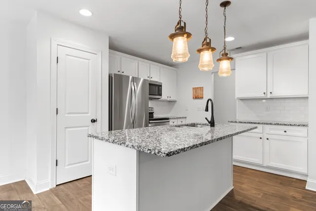 a kitchen with stainless steel appliances granite countertop a sink refrigerator and microwave