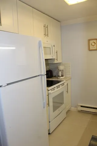 a white refrigerator freezer and a stove sitting inside of a kitchen
