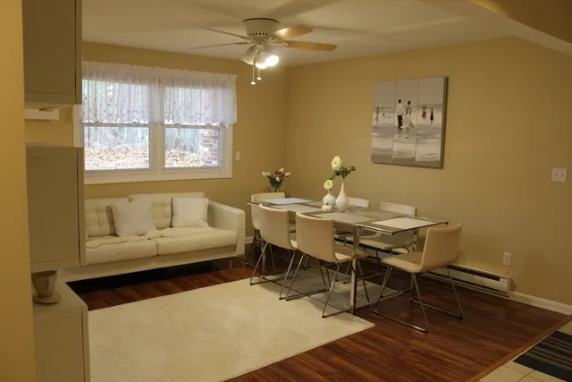 a living room with a table chairs and a potted plant
