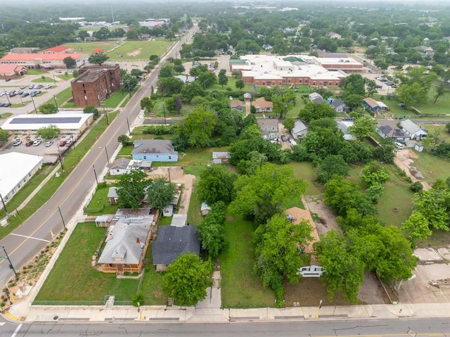 an aerial view of residential houses with outdoor space and trees