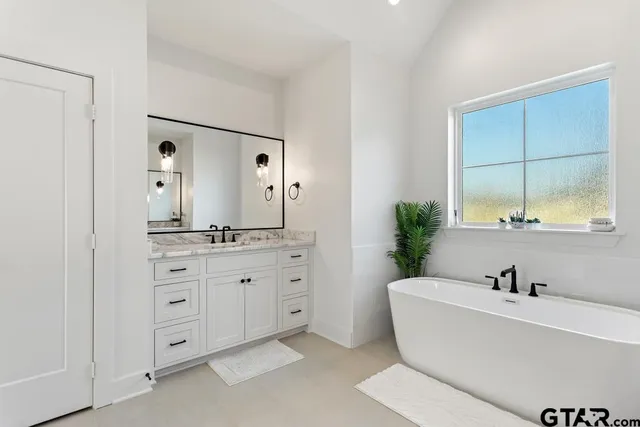 a bathroom with a tub sink and mirror