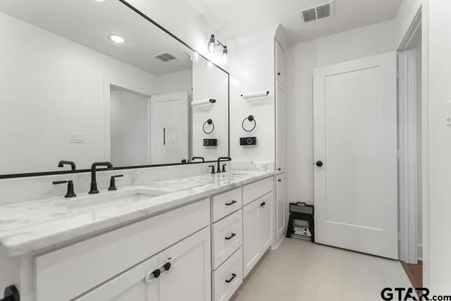 a bathroom with double sink and a mirror