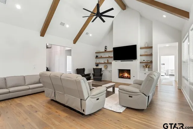a living room with furniture a flat screen tv and a fireplace