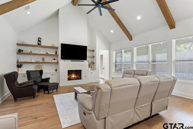 a living room with furniture a fireplace and a flat screen tv