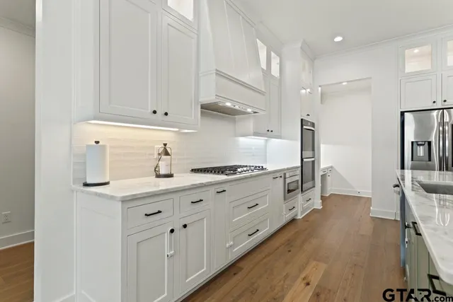 a kitchen with white cabinets and sink