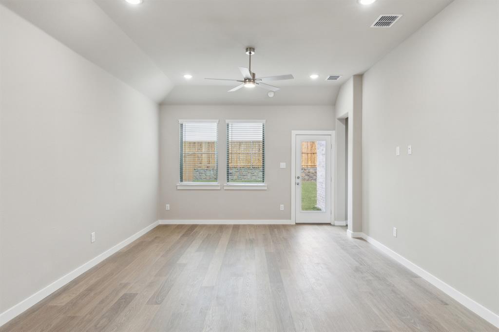 8308 Coastal Lane Pilot Point, TX 76258 - Photo 14 of 32 an empty room with wooden floor and windows