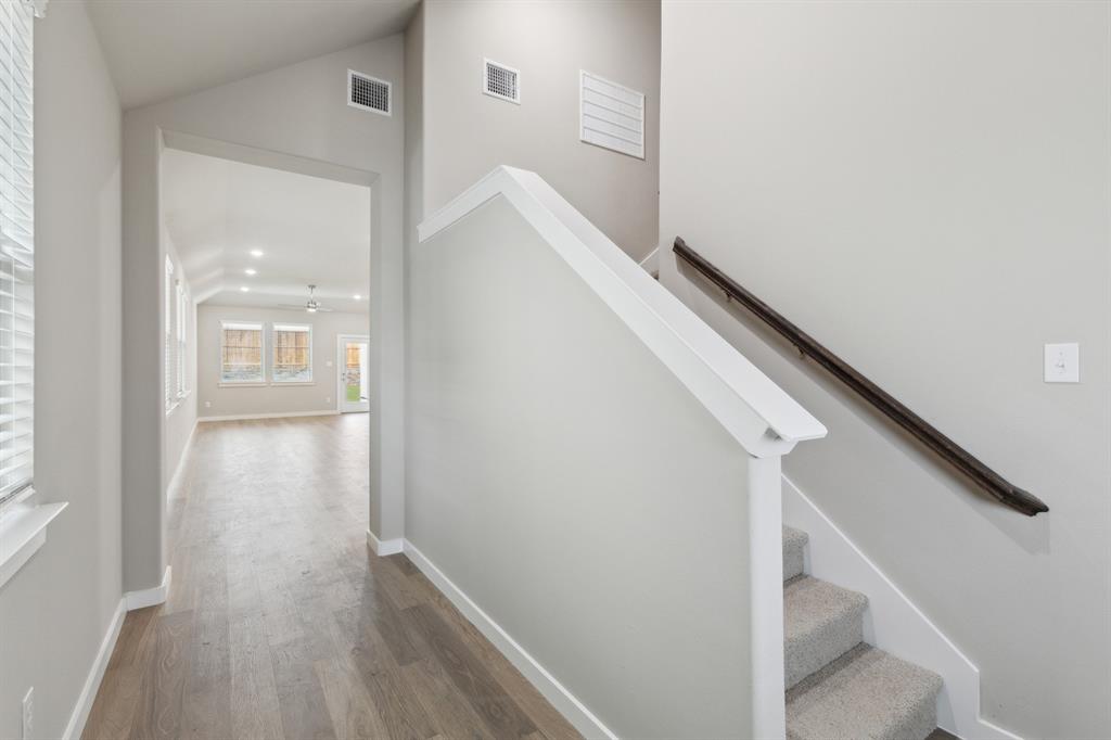 8308 Coastal Lane Pilot Point, TX 76258 - Photo 29 of 32 a view of a hallway with wooden floor and staircase