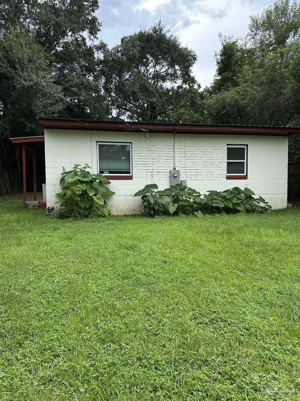 a view of backyard of house with green space