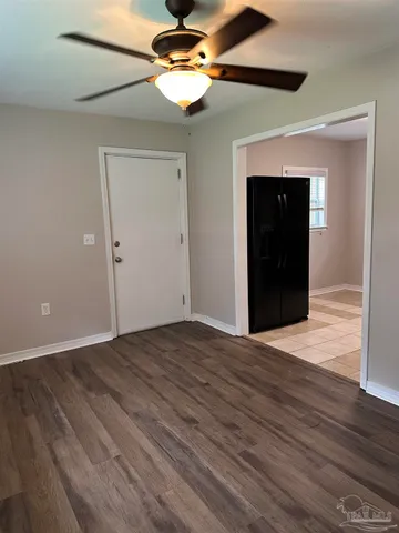 a view of empty room with wooden floor