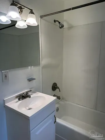 a bathroom with a sink mirror and a bathtub