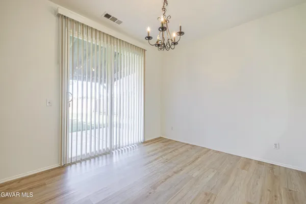 a kitchen with stainless steel appliances granite countertop a refrigerator a sink dishwasher a stove and white cabinets with wooden floor