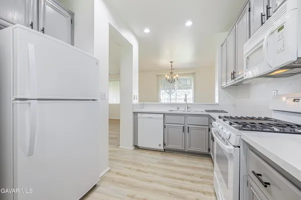 a large kitchen with stainless steel appliances a large counter top a stove and a refrigerator