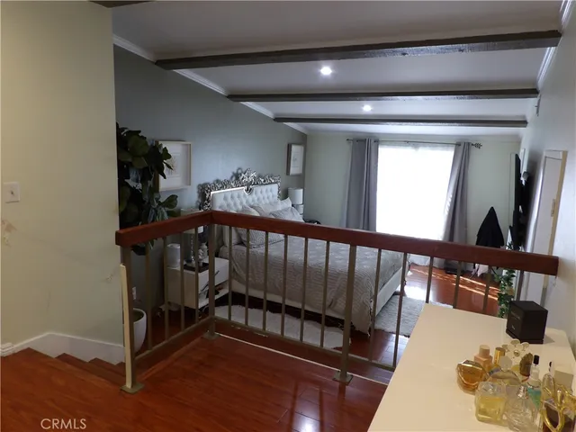 a bedroom with a bed and a potted plant on the dresser