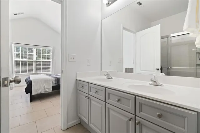 a en suite bathroom with double vanity and a mirror