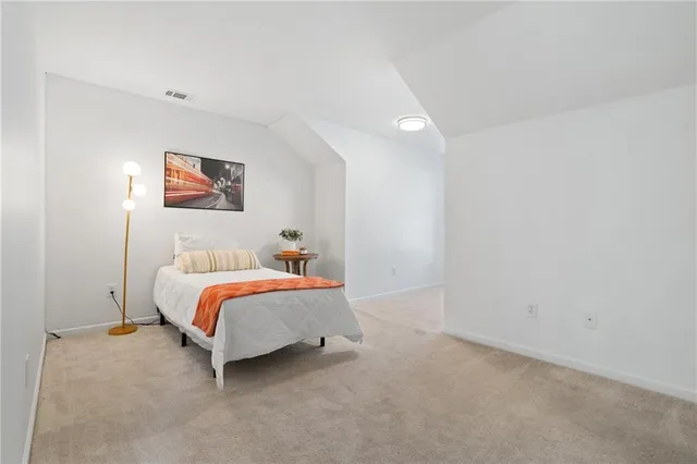 a bedroom with a bed and a painting on the wall