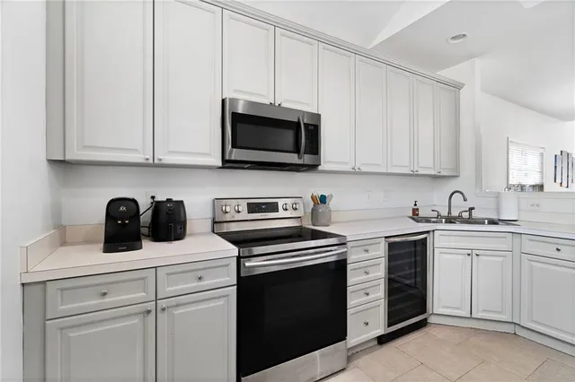 a kitchen with white cabinets and stainless steel appliances
