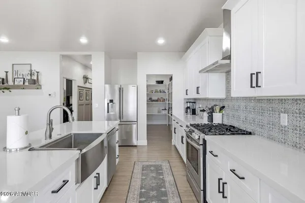 a kitchen with stainless steel appliances granite countertop a sink stove and refrigerator