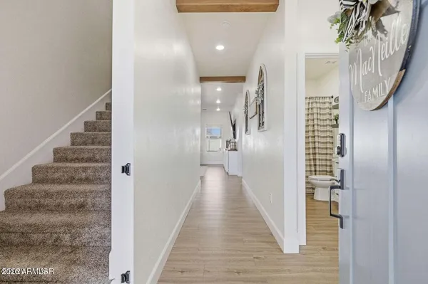 a view of a hallway with wooden floor and staircase