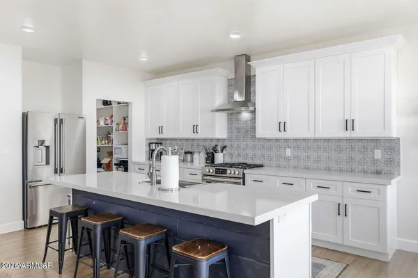 a kitchen with stainless steel appliances granite countertop a sink a stove and white cabinets