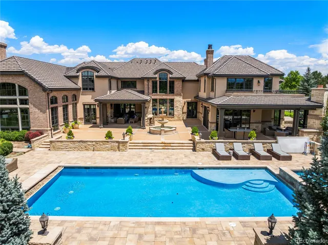 a view of a house with swimming pool and a small yard