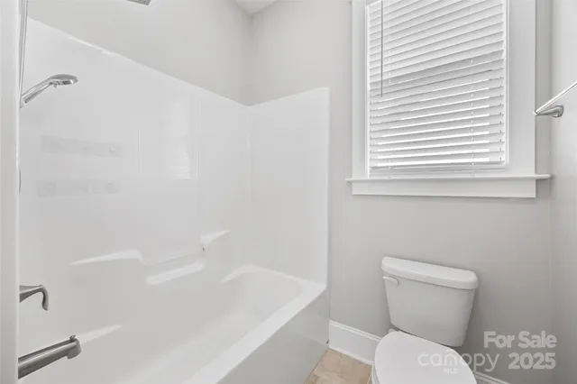 a white toilet sitting next to a bath tub