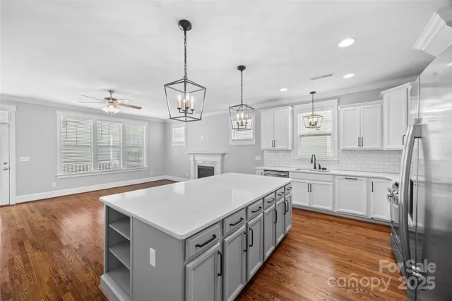 a kitchen that has a lot of cabinets and wooden floor