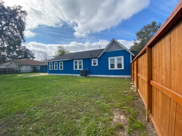 a view of a house with a small yard and wooden fence