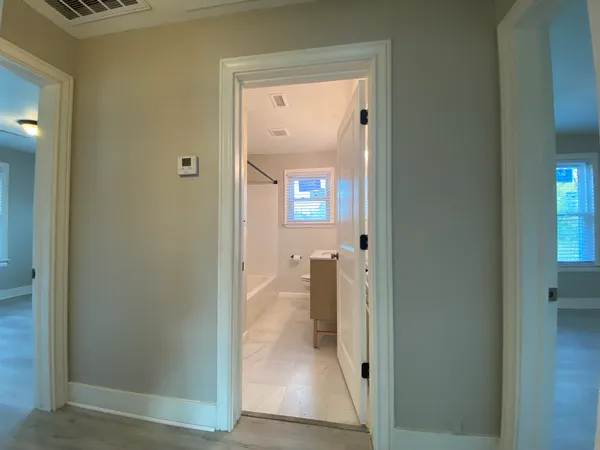 view of a hallway with wooden floor and a dining room