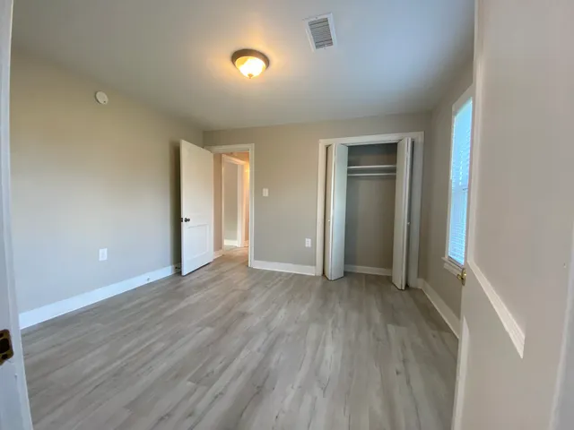 an empty room with wooden floor and closet