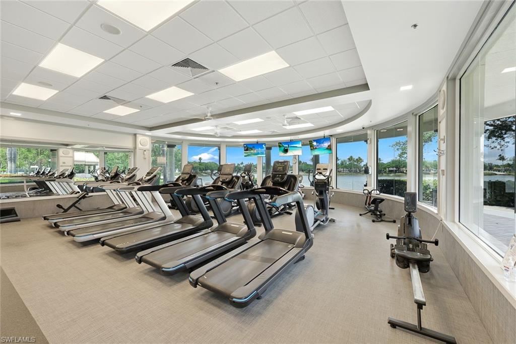 3108 Dominica Way Naples, FL 34119 - Photo 35 of 39 Fitness center featuring a variety of cardio equipment, expansive windows which look onto the lake.
