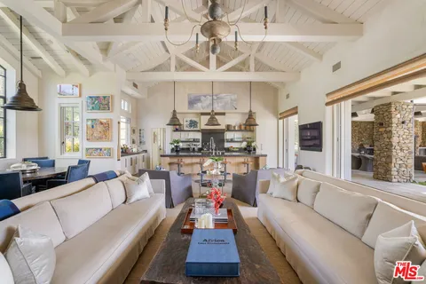 a living room with furniture a chandelier and a fireplace