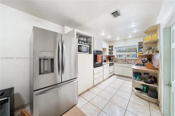 a kitchen with white cabinets and white appliances